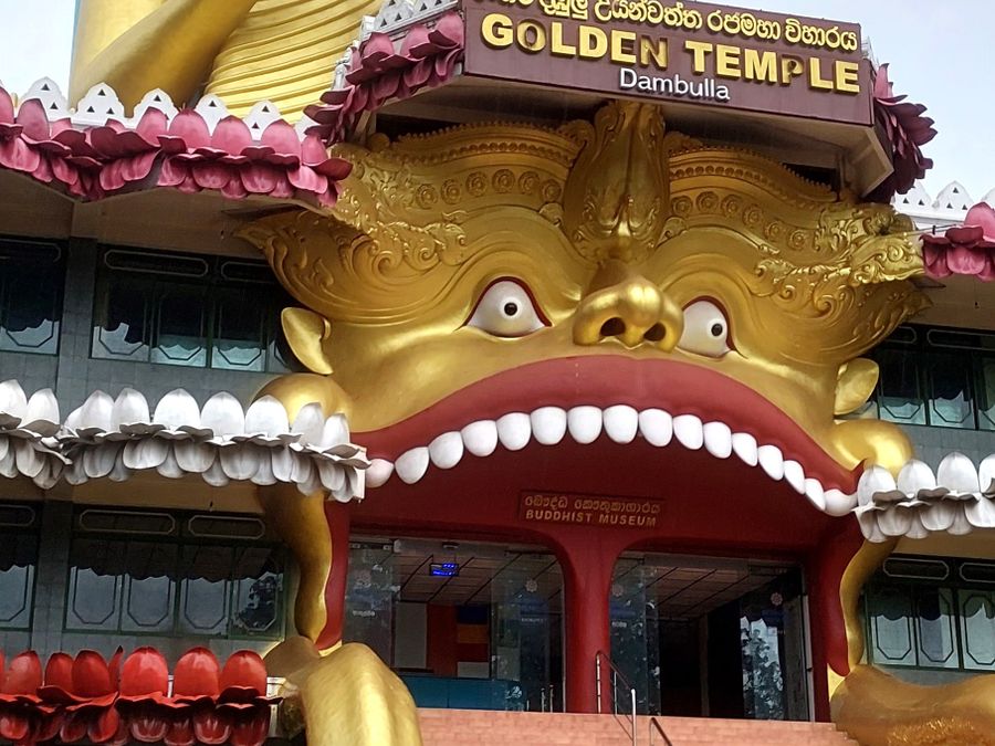 The golden Buddha statue and tiered roof of the cave temple complex at Dambulla