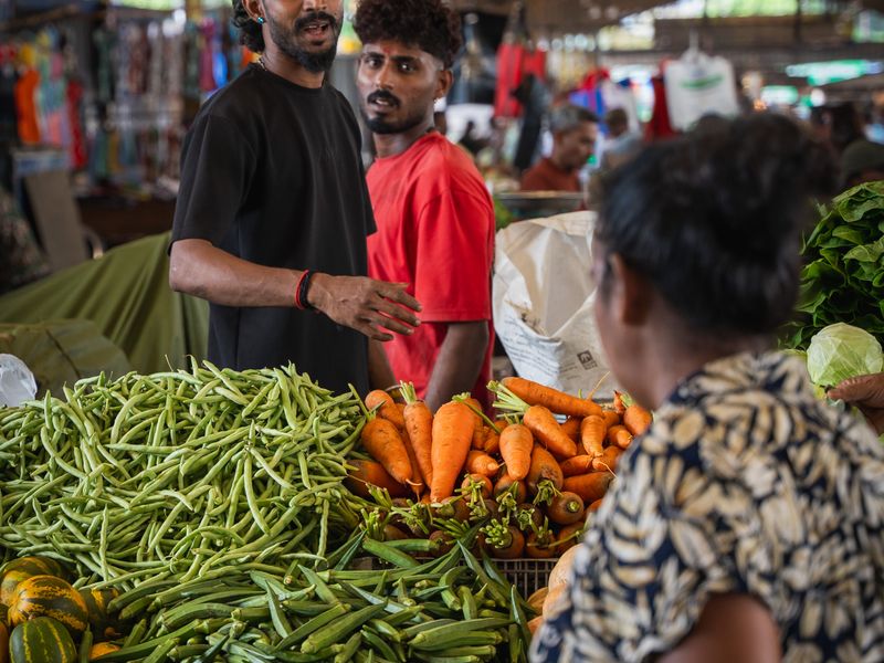Vendors and shoppers at a colourful vegetable market in Colombo, Sri Lanka.